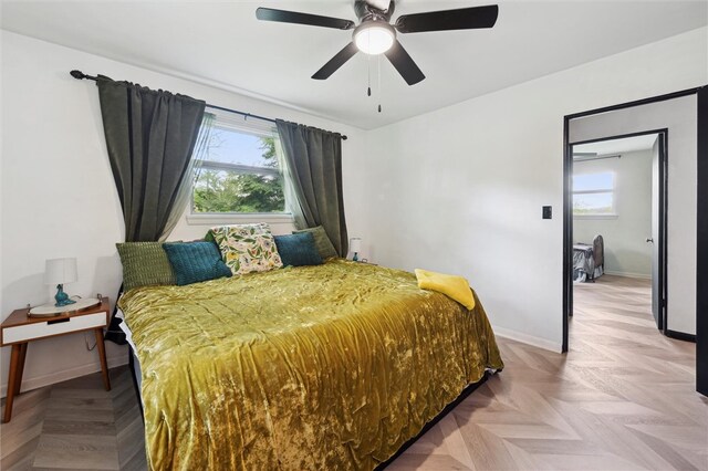 bedroom featuring multiple windows, baseboards, and a ceiling fan