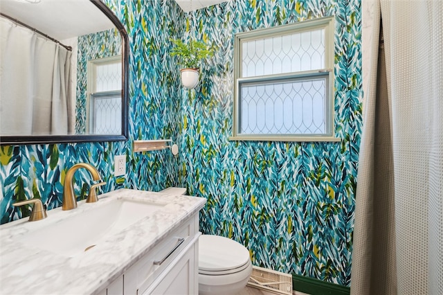 full bath with wallpapered walls, toilet, and vanity