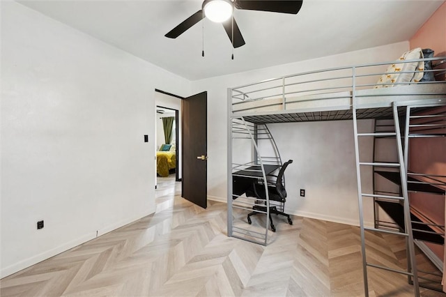 bedroom featuring baseboards and an office area