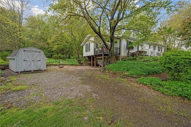 view of yard featuring stairway, a storage unit, an outbuilding, and a deck