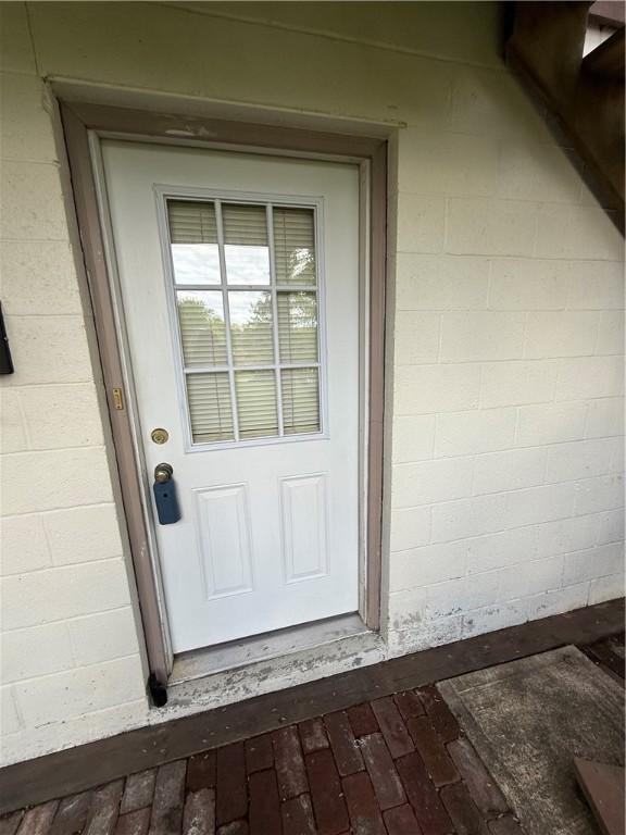 doorway to property featuring concrete block siding