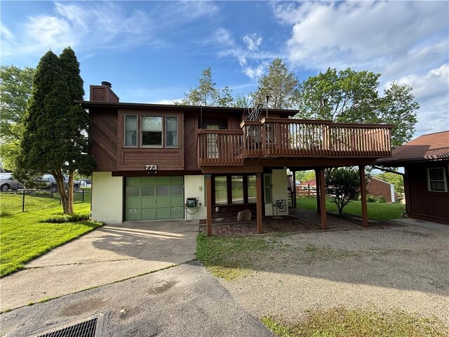 view of front of home featuring a garage, driveway, a chimney, and a wooden deck
