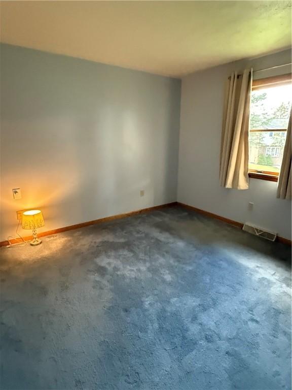 unfurnished room featuring carpet floors and baseboards