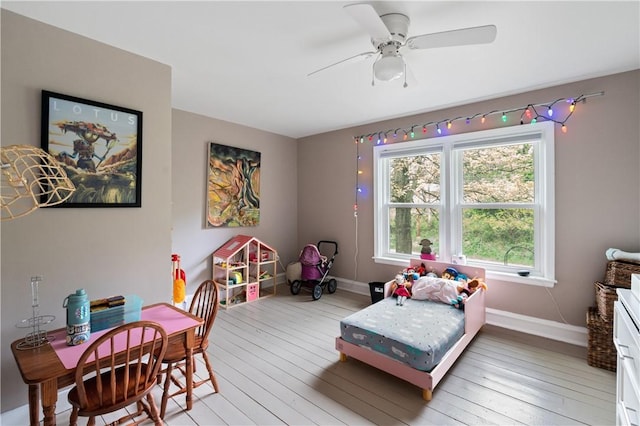 bedroom with light wood-type flooring, baseboards, and a ceiling fan