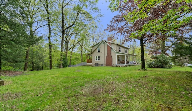 view of side of property with a chimney and a yard