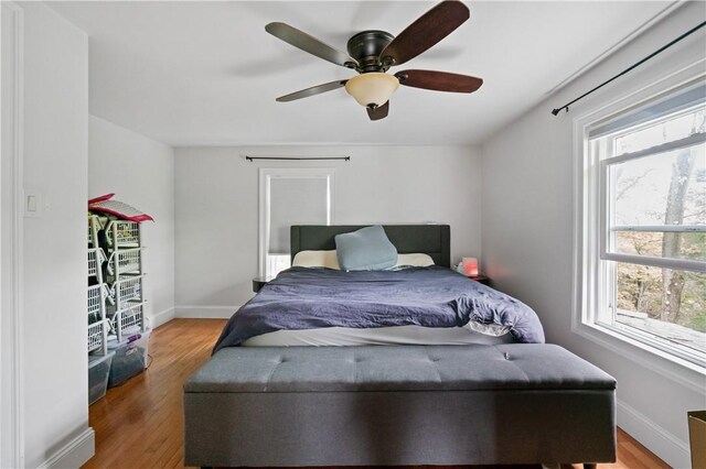 bedroom featuring multiple windows, light wood-type flooring, and baseboards