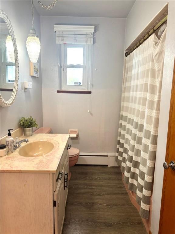 112 Dolphin Dr, Twp Of But Se, PA 16002 - full bathroom featuring baseboard heating, wood finished floors, toilet, and vanity