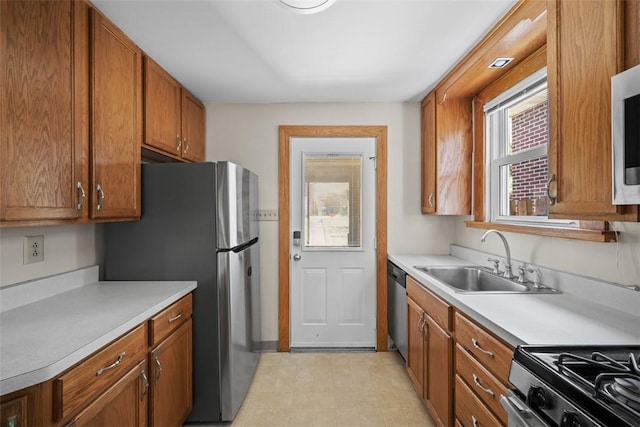 7208 Raymond St, Swissvale, PA 15218 - kitchen featuring a sink, appliances with stainless steel finishes, light countertops, and brown cabinetry