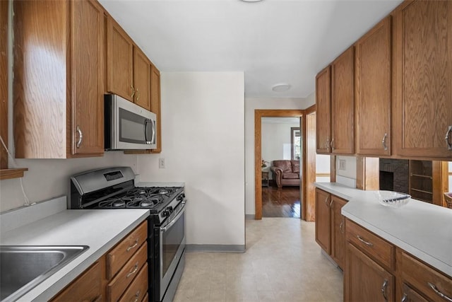 7208 Raymond St, Swissvale, PA 15218 - kitchen with appliances with stainless steel finishes, baseboards, brown cabinetry, and light countertops