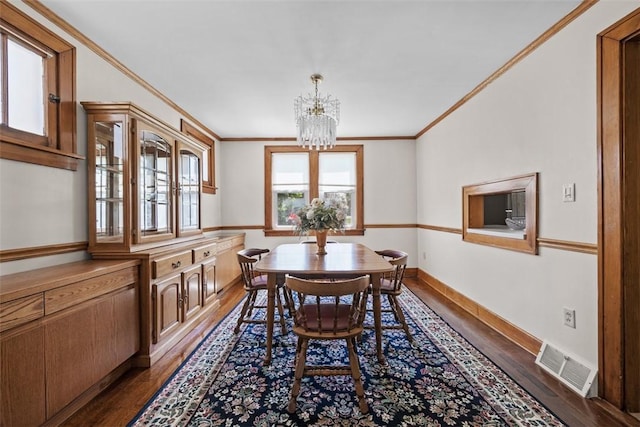 7208 Raymond St, Swissvale, PA 15218 - dining space with ornamental molding, dark wood-style flooring, a chandelier, and baseboards