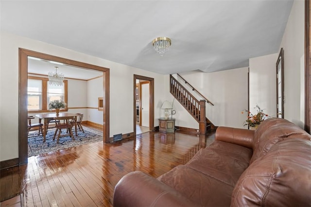 7208 Raymond St, Swissvale, PA 15218 - living room featuring a chandelier, hardwood / wood-style flooring, stairs, and baseboards