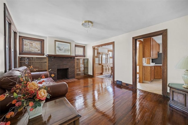 7208 Raymond St, Swissvale, PA 15218 - living room with hardwood / wood-style floors, baseboards, and a brick fireplace