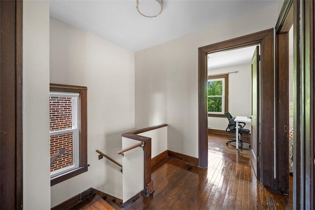 7208 Raymond St, Swissvale, PA 15218 - hall with dark wood finished floors, baseboards, a desk, and an upstairs landing