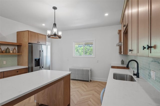kitchen with radiator, high end refrigerator, a sink, light countertops, and open shelves