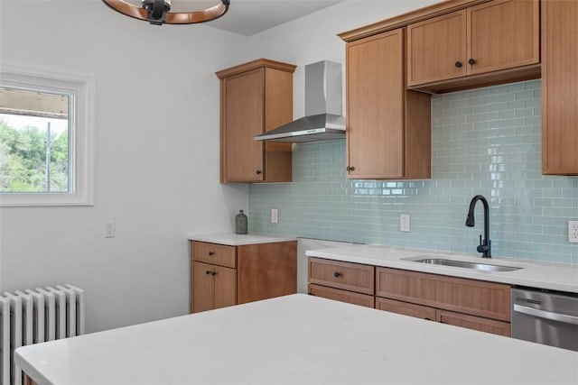 kitchen featuring radiator, a sink, wall chimney exhaust hood, decorative backsplash, and light countertops