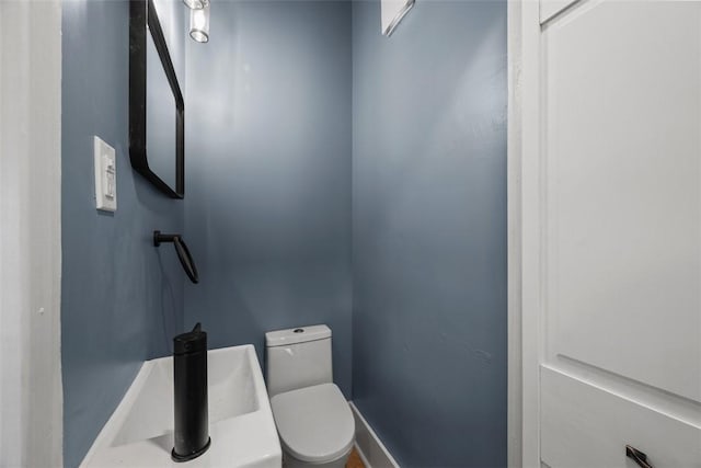 half bath with toilet and baseboards