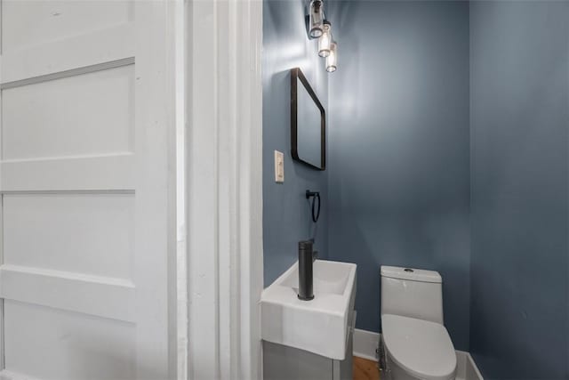 half bathroom with toilet and baseboards