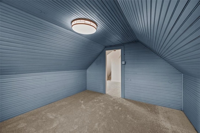 additional living space featuring carpet flooring, vaulted ceiling, wood walls, and wood ceiling