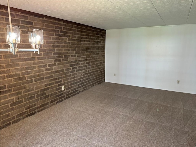 empty room featuring carpet and brick wall