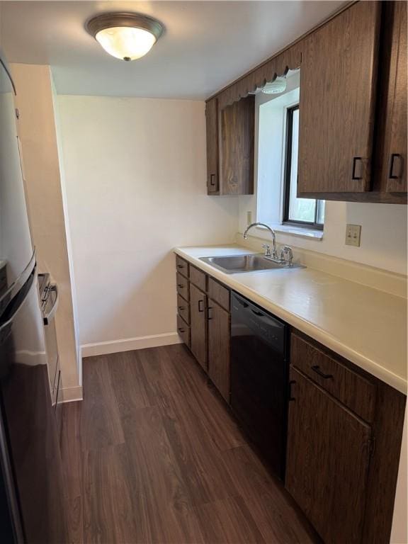 kitchen featuring a sink, dishwasher, dark wood-style floors, baseboards, and light countertops