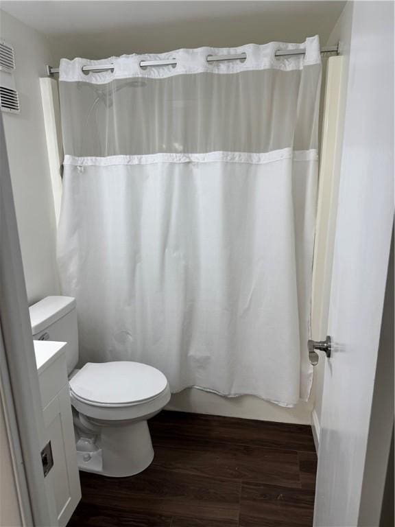 full bath featuring wood finished floors, vanity, toilet, and shower / tub combo