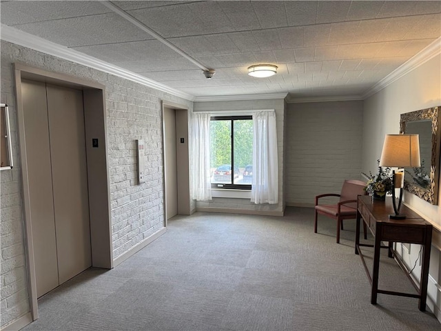 sitting room with elevator, ornamental molding, carpet flooring, and brick wall