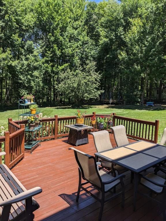 106 Arbor Trl, Slippery Rock Boro, PA 16057 - wooden terrace with outdoor dining area, a lawn, and a fire pit