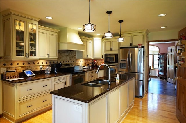 106 Arbor Trl, Slippery Rock Boro, PA 16057 - kitchen featuring appliances with stainless steel finishes, custom exhaust hood, cream cabinets, a sink, and light wood-type flooring