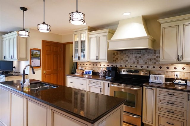 106 Arbor Trl, Slippery Rock Boro, PA 16057 - kitchen featuring stainless steel electric stove, custom range hood, a sink, an island with sink, and tasteful backsplash
