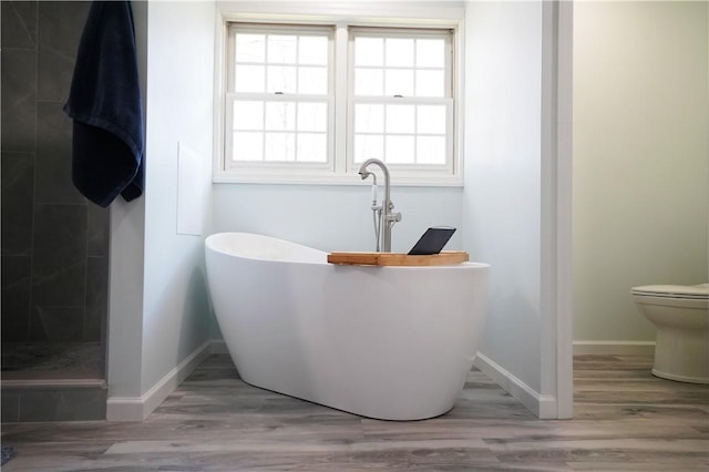106 Arbor Trl, Slippery Rock Boro, PA 16057 - bathroom featuring a soaking tub, baseboards, wood finished floors, and toilet