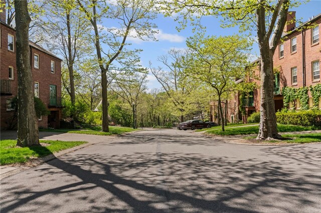 view of asphalt road with curbs and sidewalks
