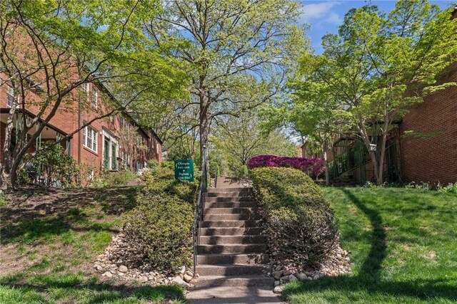 view of property's community with stairway and a yard