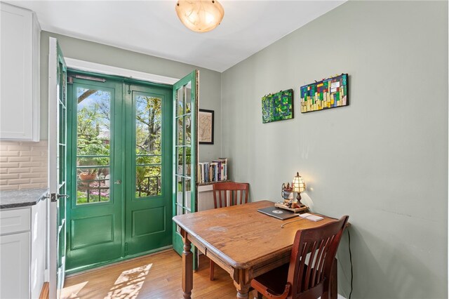 dining area with french doors and light wood-style flooring