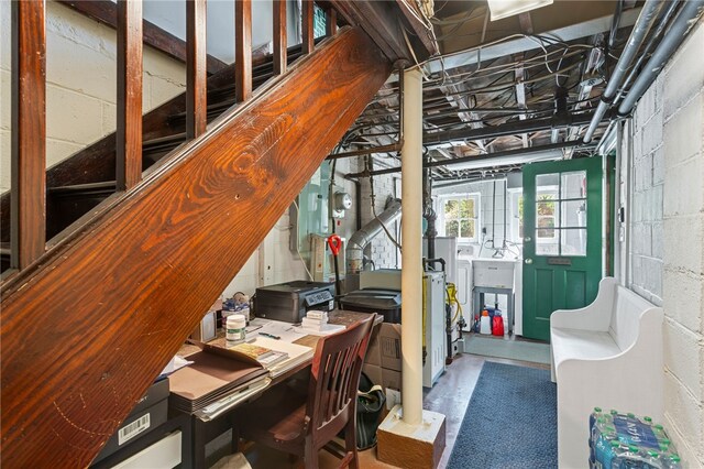 office space featuring concrete block wall and separate washer and dryer
