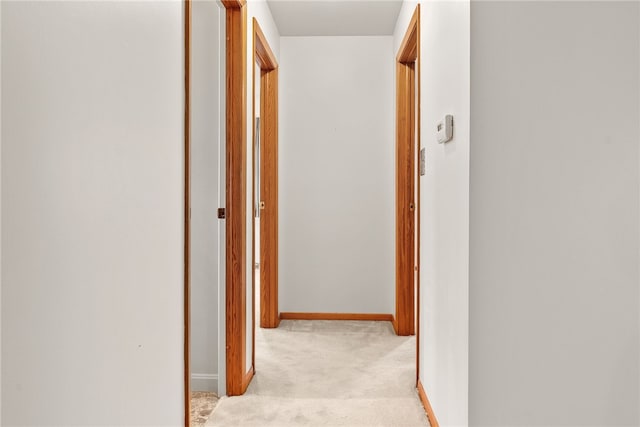 corridor with light carpet and baseboards