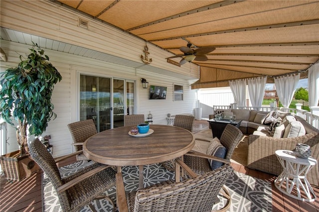 sunroom featuring outdoor lounge area, outdoor dining area, a ceiling fan, and vaulted ceiling