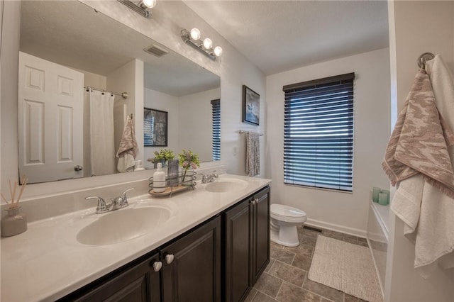 full bathroom featuring toilet, double vanity, curtained shower, tile patterned flooring, and baseboards