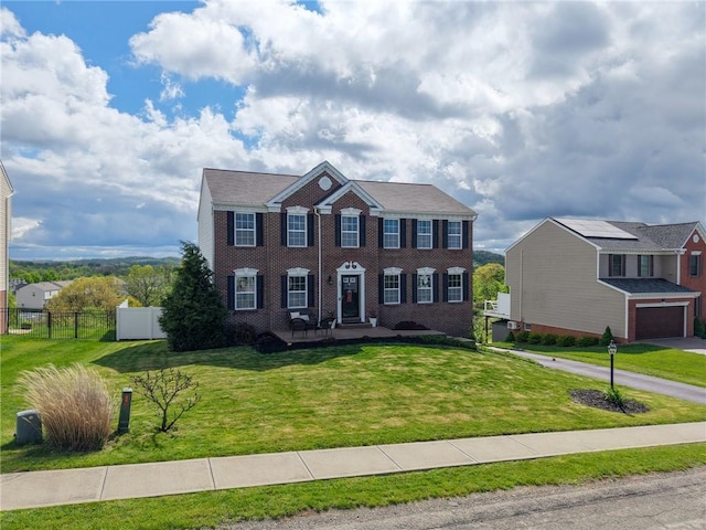 colonial home with a garage and brick siding