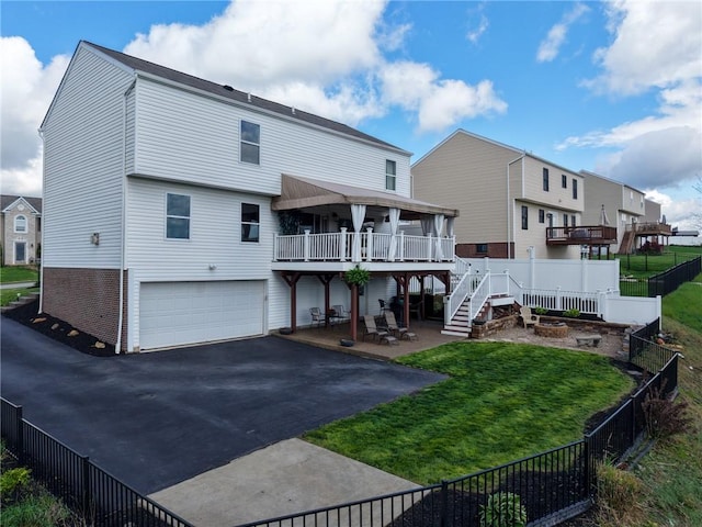 back of house featuring a garage, asphalt driveway, stairway, a patio, and a deck