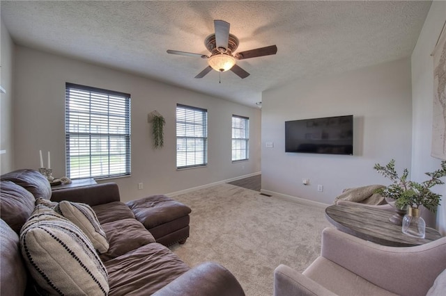carpeted living area with a textured ceiling, ceiling fan, and baseboards