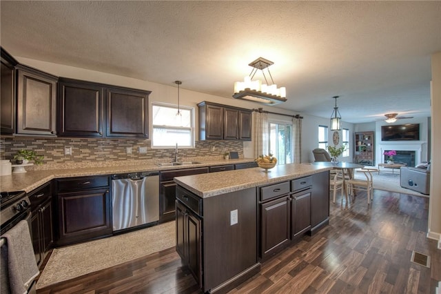 kitchen with dishwasher, open floor plan, dark brown cabinetry, a center island, and backsplash