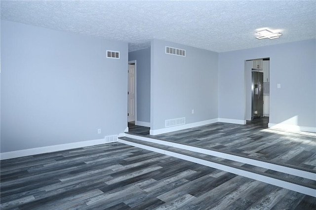unfurnished room with dark wood-style floors, baseboards, and a textured ceiling