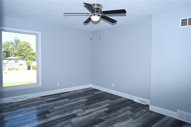 spare room with a textured ceiling, dark wood-type flooring, baseboards, and ceiling fan