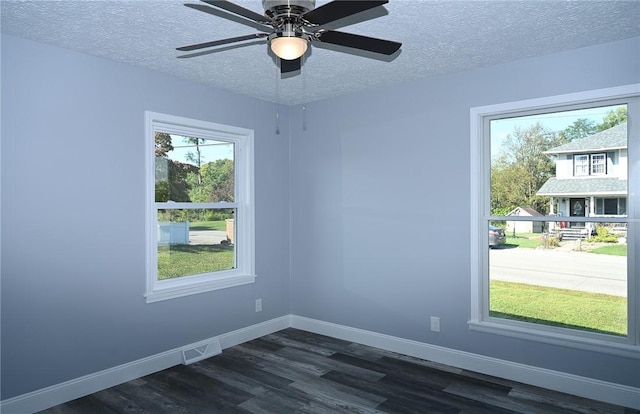 spare room with dark wood-style floors, a textured ceiling, baseboards, and ceiling fan