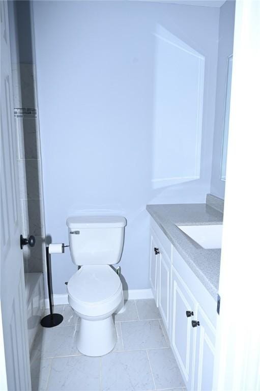bathroom with vanity, baseboards, and toilet