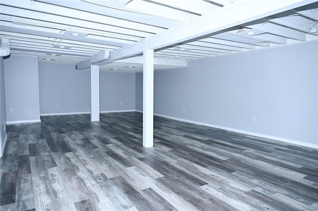 finished below grade area featuring wood finished floors and baseboards
