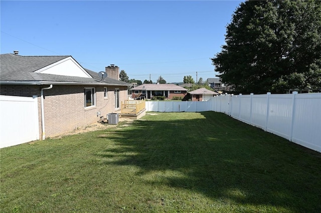 view of yard with a deck and central AC unit