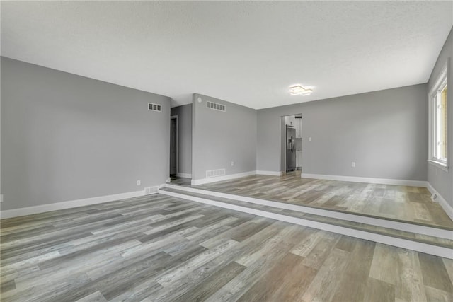 1301 Bechtel St, Monaca, PA 15061 - spare room with light wood-style flooring and a textured ceiling