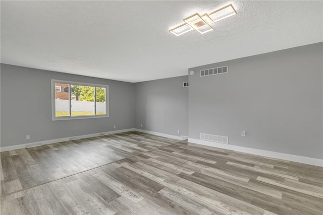 1301 Bechtel St, Monaca, PA 15061 - spare room with wood finished floors and a textured ceiling