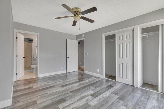 1301 Bechtel St, Monaca, PA 15061 - unfurnished bedroom with wood finished floors, a closet, a textured ceiling, ensuite bath, and a ceiling fan
